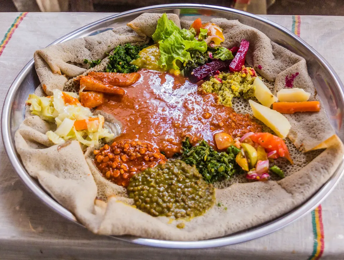 Injera mit Beilagen auf einer traditionellen Platte
